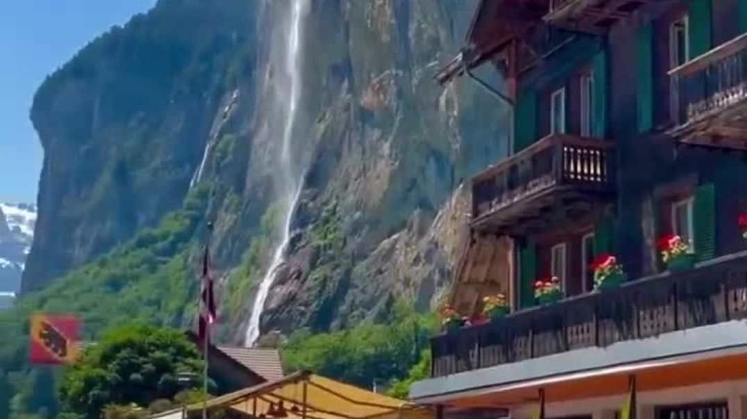 ⁣A video of Lauterbrunnen Valley in Switzerland featuring towering cliffs with powerful waterfalls